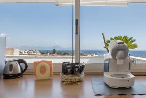 um secador de cabelo sentado numa mesa em frente a uma janela em Apartment Martucci with Seaview em Nápoles