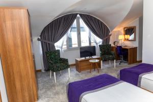 a hotel room with a bed and a desk and a room at Business Palas Otel in Kocaeli