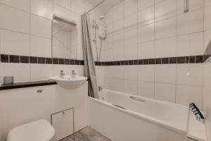 a bathroom with a sink and a toilet and a tub at Central Park Place in Whitby