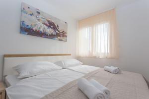 um quarto com uma grande cama branca com toalhas em Apartment Papillon em Split