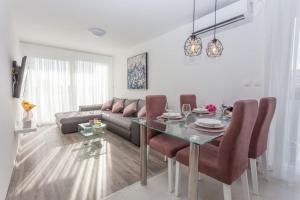 uma sala de estar com uma mesa e um sofá em Apartment Papillon em Split