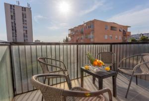 uma varanda com cadeiras e uma mesa com laranjas em Apartment Papillon em Split