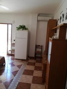 een keuken met een witte koelkast en een geruite vloer bij Villa Natalia in Málaga