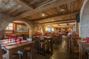 uma sala de jantar com mesas e cadeiras de madeira em Luna Chalets da Montanha - Serra da Estrela na Covilh mais 30 fotografias