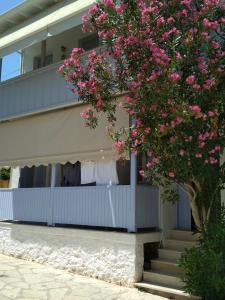 ein Gebäude mit einem Balkon mit rosa Blumen in der Unterkunft Konstantina Studios in Agios Nikitas