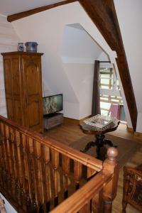 een woonkamer met een houten trap en een tafel bij Gîtes les bains in Riquewihr