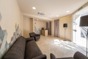 a living room with a couch and two chairs at Hotel Victori in Es Castell +41 photos