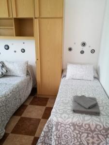 een kleine kamer met 2 bedden en een kast bij Villa Natalia in Málaga