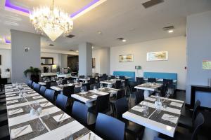 a conference room with tables and chairs and a chandelier at Oceano Atlantico Apartamentos Turisticos in Portimão