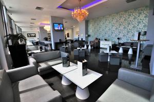 a restaurant with couches and tables and a chandelier at Oceano Atlantico Apartamentos Turisticos in Portimão