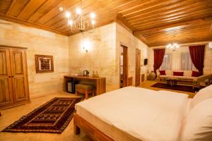 a bedroom with a bed and a desk in a room at ikarus Cappadocia Hotel in Uchisar