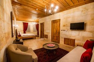 a living room with a couch and a tv at ikarus Cappadocia Hotel in Uchisar