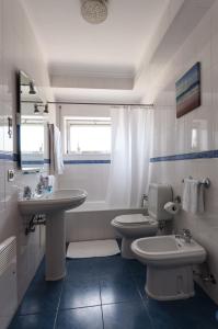 a bathroom with two toilets and a sink at Apartamentos Turisticos Ceu Azul in Arcozelo