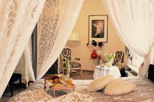 ein Schlafzimmer mit einem Bett mit Vorhängen und einem Tisch in der Unterkunft Hotel Simonis in Kobern-Gondorf