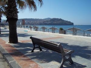 a park bench sitting on a sidewalk near the water at Valente rooms in Agropoli +18 photos
