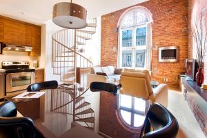 a spiral staircase in a living room with a brick wall at Les Lofts 1048 in Quebec City