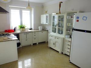 a kitchen with white cabinets and a white refrigerator at Dom Tulipan in Krynica Zdrój