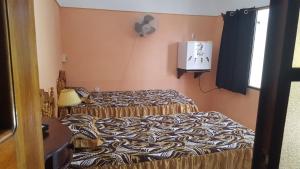 a room with two beds and a tv on the wall at Casa El pescador in Playa Larga