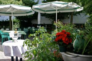 two umbrellas and a table with plants and flowers at Hotel Leander in Bitburg