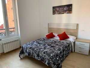 1 dormitorio con 1 cama con 2 almohadas rojas en Alba Renueva 6, en León
