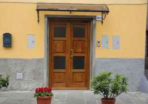 a wooden door on a building with flowers in pots at La Piccola Oasi Toscana in Bagni di Lucca +20 photos