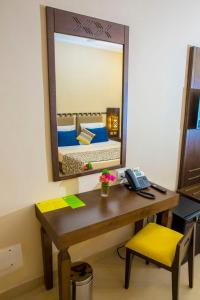 a room with a desk with a mirror and a bed at Dunia Hôtel Ouagadougou Loumbila in Loumbila +28 photos