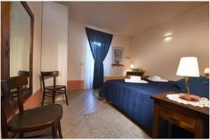 a bedroom with a blue bed and a table and chairs at La Rosa nel Borgo in La Morra