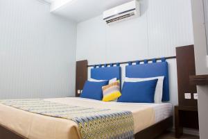 a bedroom with a bed with blue and yellow pillows at Dunia Hôtel Ouagadougou Loumbila in Loumbila
