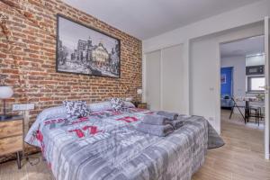 sypialnia z ceglaną ścianą i dużym łóżkiem w obiekcie Ever House - ALCALA CIELO 2 ROOFTOP w Madrycie