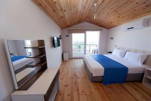 1 dormitorio con 1 cama grande y espejo en Metins Gümüşlük en Bodrum