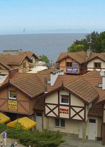 a group of houses with roofs in front of the ocean at Siódme Niebo-komfortowe pokoje nad samym morzem in Stegna