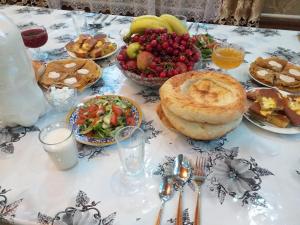 a table topped with pies and a bowl of fruit at EcoUlan in Kochkorka