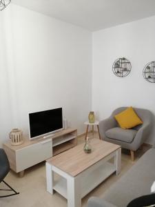 a living room with a couch and a tv at Sueños Mozárabes in Córdoba