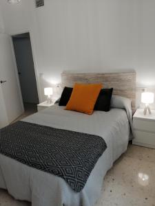 een slaapkamer met een bed met een oranje kussen erop bij Sueños Mozárabes in Córdoba