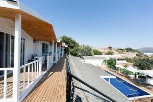 a balcony of a house with a swimming pool at Metins Gümüşlük in Bodrum City