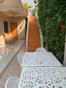 a white table and chairs on a patio with a staircase at Casa Colonial Familia Azcuy in Viñales