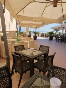 a patio with a table and chairs and an umbrella at Hotel Calgary in Casalbordino