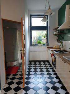 a kitchen with a black and white checkered floor at Guesthouse Prusa 7 in Oświęcim