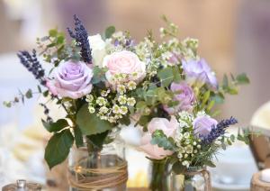 eine Gruppe von Vasen, gefüllt mit rosa Rosen und Lavendel in der Unterkunft Rossett Hall Hotel in Rossett