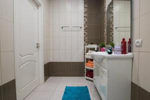 baño con lavamanos y ducha con alfombra azul en Apartment on Tverskaya, en Moscú