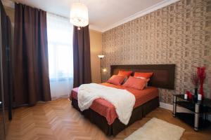 a bedroom with a bed with orange pillows and a window at Apartment on Tverskaya in Moscow