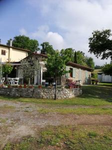 a house with a stone wall in front of a yard at Il Podere della piazza in Scarperia