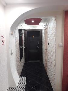 ノヴォクズネツクにある3-комнатная квартира в районе ЖД ВОКЗАЛАの黒いドアと黒いタイルフロアの廊下