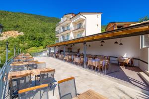 een restaurant met tafels en stoelen op een balkon bij Pansion Villa Betina in Lovran