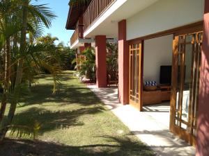 a walkway leading to a house with palm trees at PRAIA DO FORTE - CONDOMINIO VILLAGE DAS ACACIAS - PISCINAS NATURAIS in Praia do Forte
