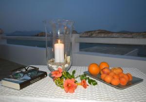 a candle and a plate of oranges on a table at Traditional Waterfront House in Mandrakia