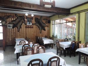 a dining room with tables and chairs and wooden walls at Motel Tetrijeb Sipovo in Šipovo