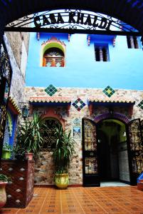 a large building with a clock on the side of it at Hotel Casa Khaldi in Chefchaouen