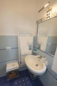Baño azul con lavabo y espejo en B&B La casa di g.g., en Grottammare