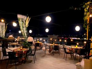 a patio with tables and chairs at night at Hotel Boutique Casa del Jardín Aguascalientes in Aguascalientes